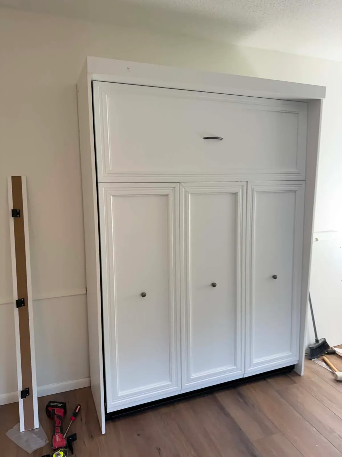 White built-in Murphy bed cabinet installed in a bedroom